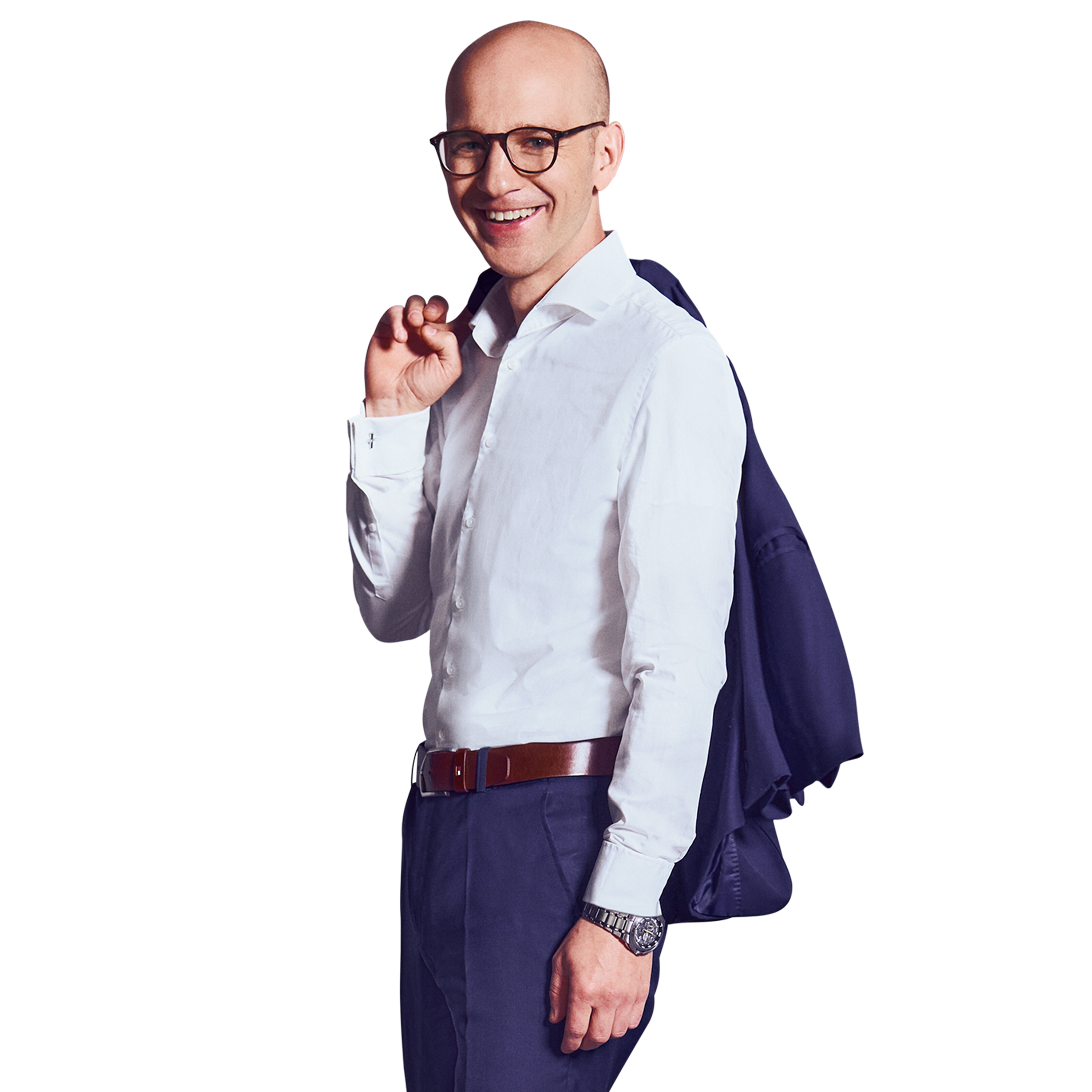 Männliche Person, keine Haare, blaue Augen mit Brille, lächelnd, trägt ein weißes Hemd und dunkelblaue Hose, stehend mit der rechten Hand das Jackett über der Schulter tragend