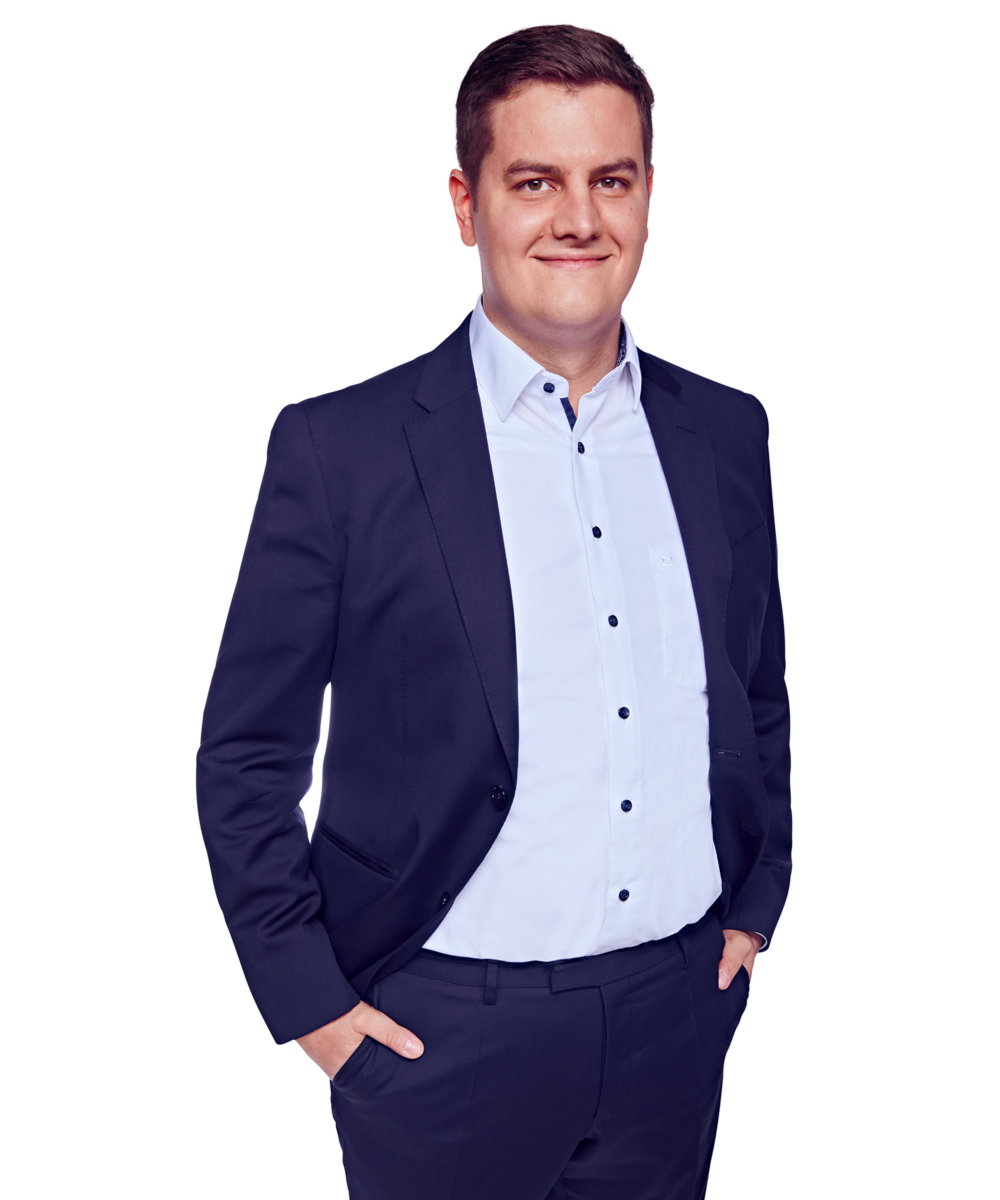 Porträtfoto von Daniel Heringer Herkner, Senior Consultant bei Kemény Boehme Consultants (KBC). Mann mit kurzem, dunkelbraunem Haar blickt leicht lächelnd in die Kamera. Trägt einen dunklen Blazer über einem hellblauen Hemd mit dunklen Knöpfen, offen ohne Krawatte, beide Hände locker in den Hosentaschen, leicht zur Seite gedrehte, entspannte und selbstbewusste Haltung.