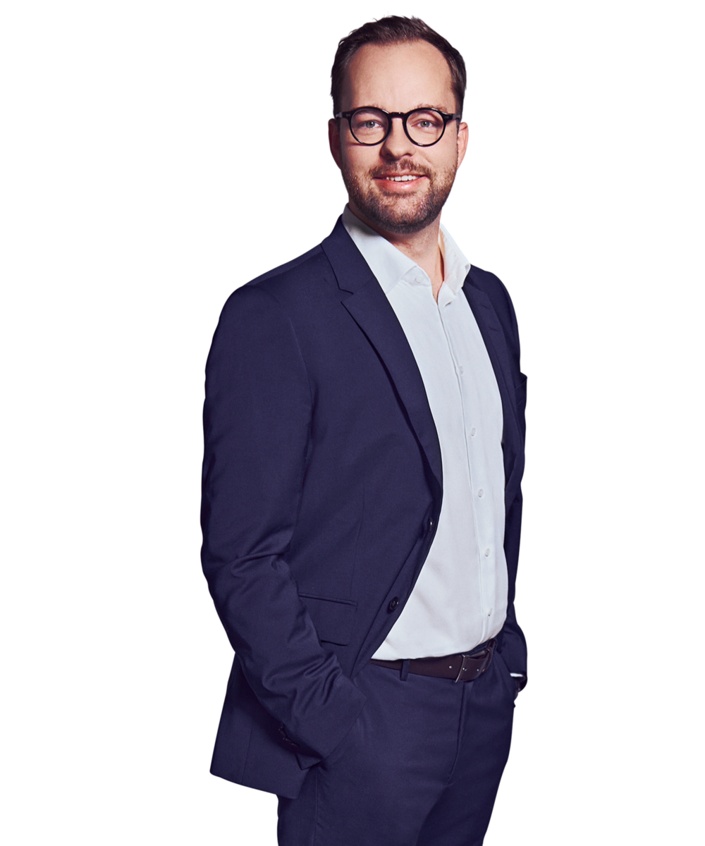 Portraitbild von Daniel Zeranski, Director bei Kemény Boehme Consultants, der lächelnd mit beiden Händen in den Hosentaschen in die Kamera blickt