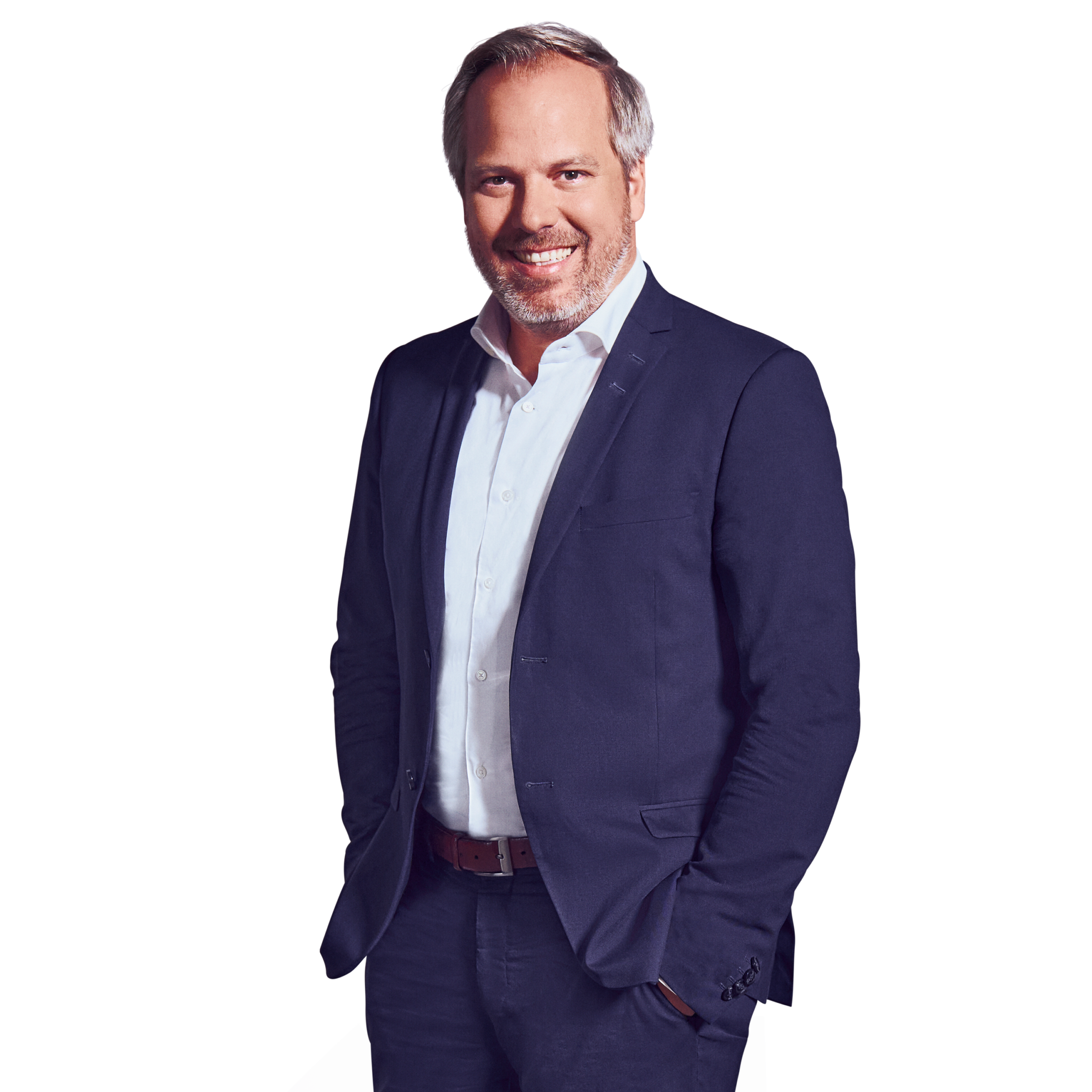 A portrait of Georg Huber, Senior Partner at Kemény Boehme Consultants, smiling at the camera with both hands in his pockets