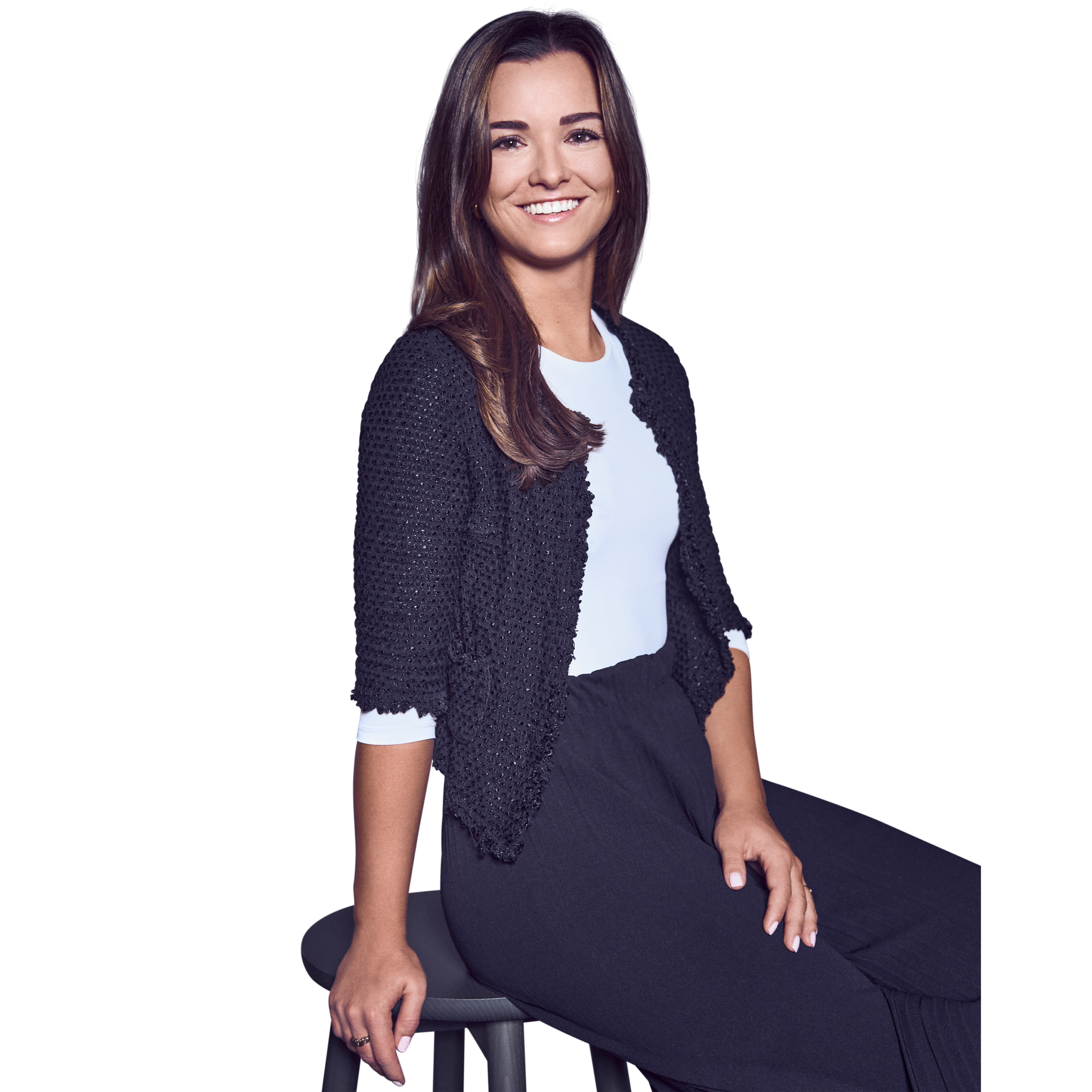 Portraitbild von Isabel Kuttenreich, Office Manager bei Kemény Boehme Consultants, die mit neutralem Gesichtsausdruck auf einem Barhocker sitzend in die Kamera blickt
