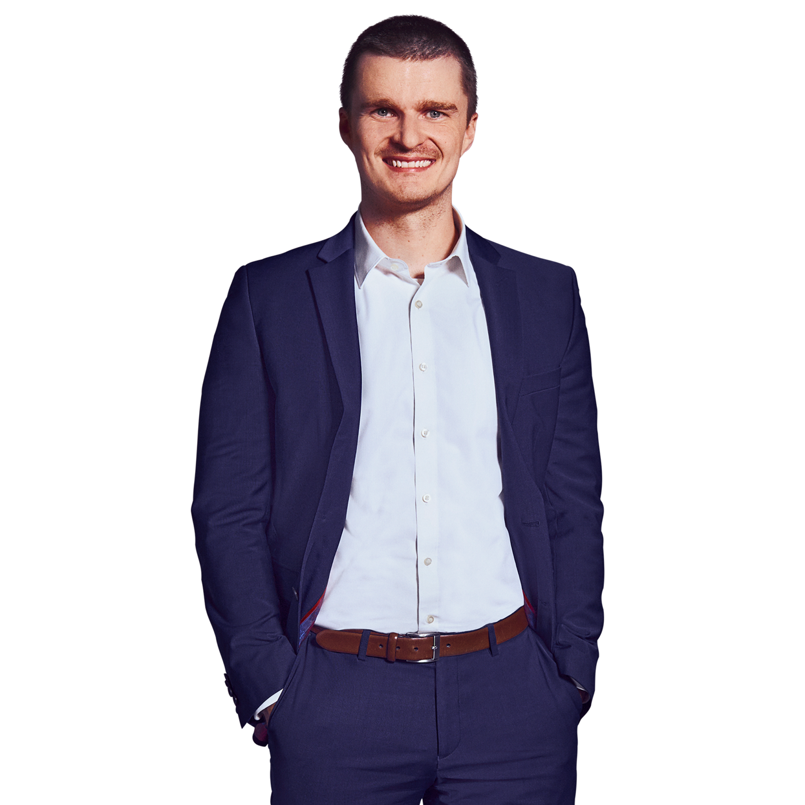 Portrait photo of Philipp Berger, Lead Software Engineer at Kemény Boehme Consultants (KBC). A man with short, dark brown hair is smiling broadly at the camera. He is wearing a dark blue suit with a matching jacket and pants over a white shirt (no tie), as well as a cognac-colored leather belt; both hands are in his pockets, and he has a relaxed and open posture.