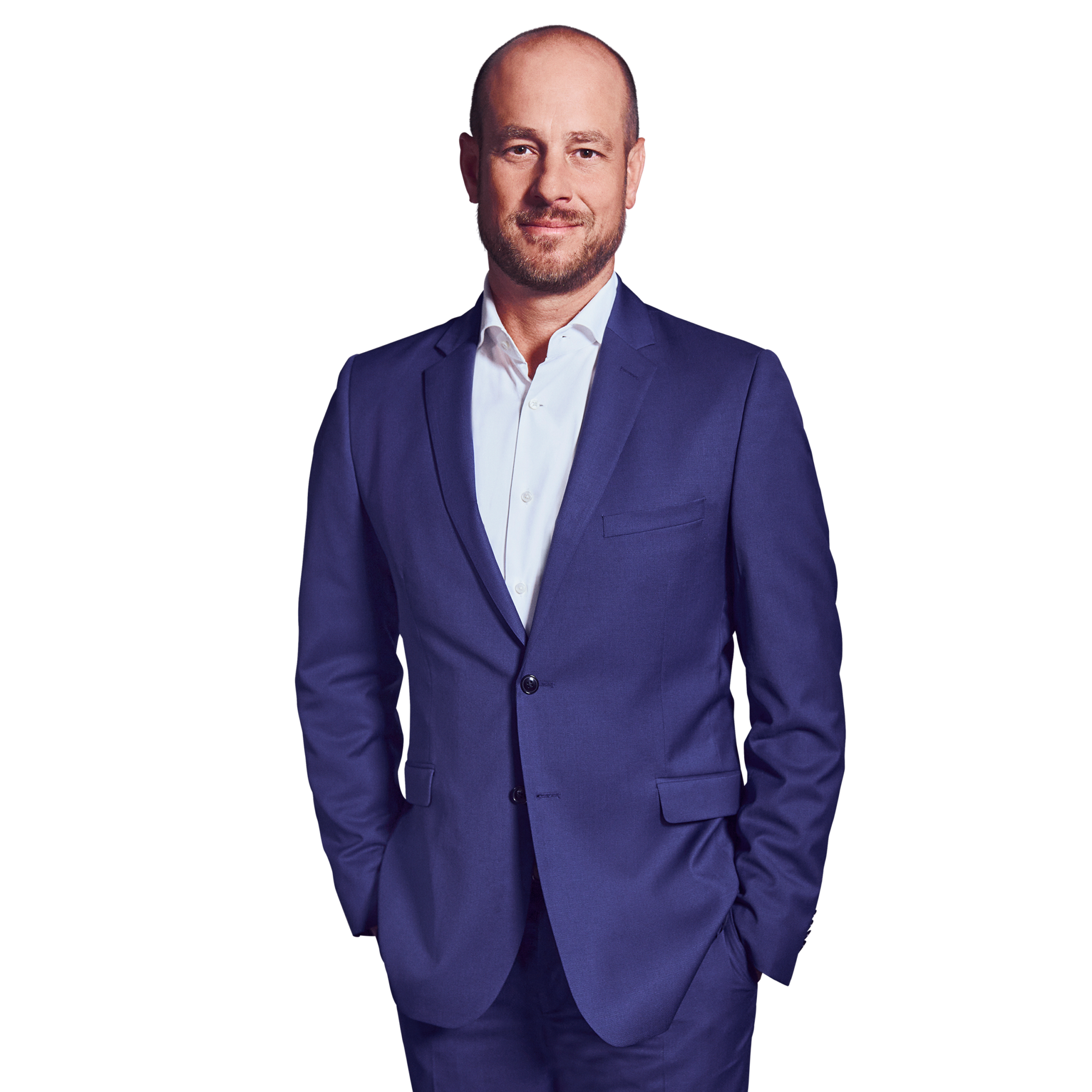 Portraitbild von Marc Perbix, Senior Partner bei Kemény Boehme Consultants, der lächelnd mit beiden Händen in den Hosentaschen in die Kamera blickt.