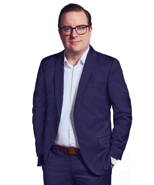 Portraitbild von Tobias Budde, Managing Partner bei Kemény Boehme Consultants, der lächelnd mit beiden Händen in den Hosentaschen in die Kamera blickt