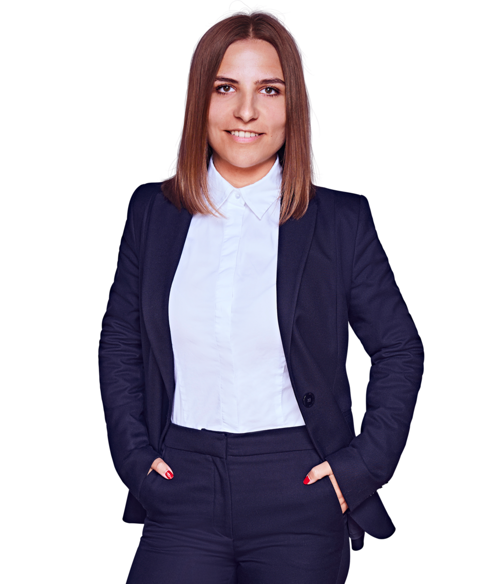 Porträtfoto von Laura Reichart, Senior Consultant bei Kemény Boehme Consultants (KBC). Frau mit schulterlangem, glattem, dunkelbraunem Haar blickt lächelnd in die Kamera. Trägt einen dunklen Hosenanzug mit passendem Sakko und Hose über einer weißen Bluse mit Kragen, beide Hände locker in den Hosentaschen, aufrechte und selbstbewusste Haltung mit roten Fingernägeln.