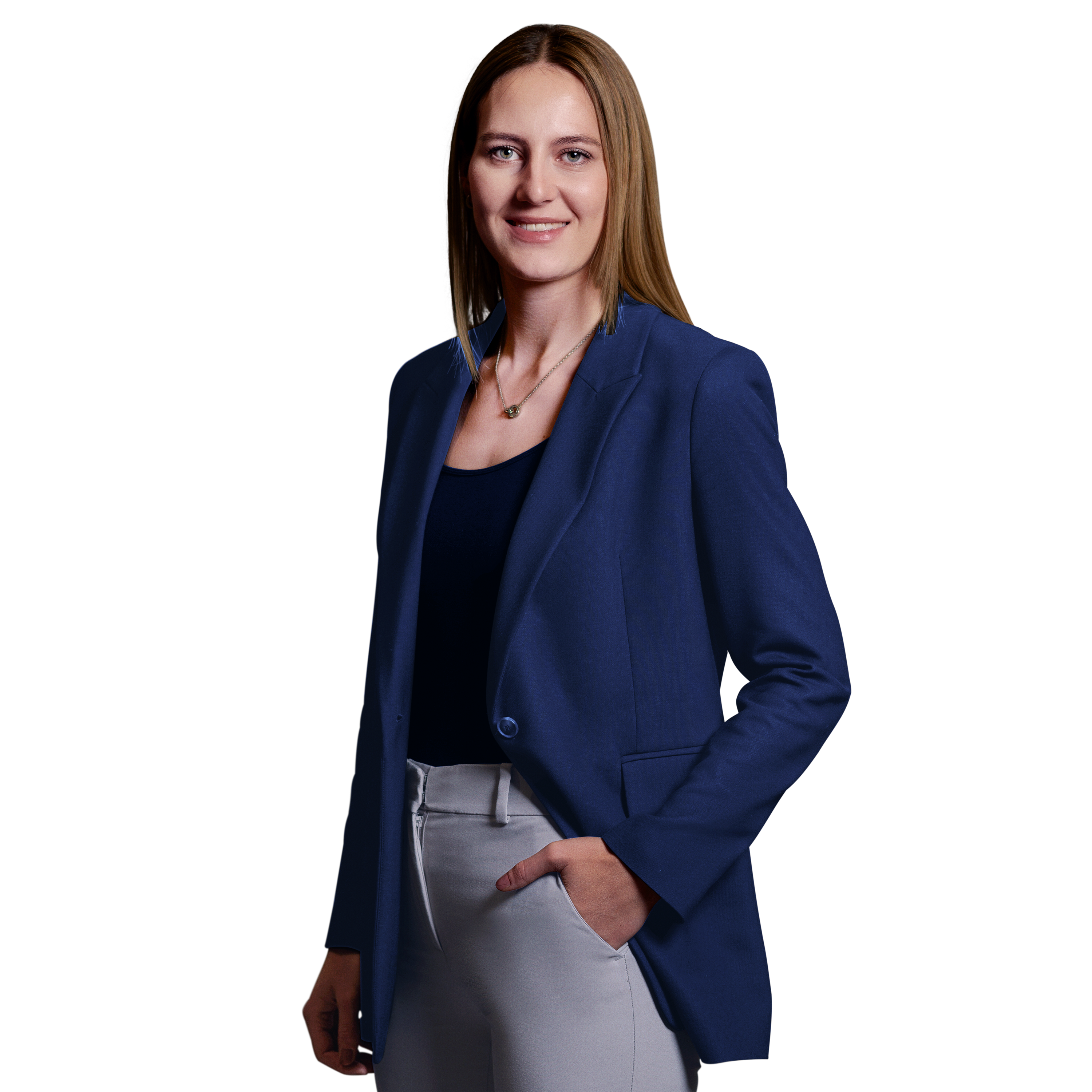 Weibliche Person, blonde mittellange Haare, grüne Augen, lächelnd, trägt ein schwarzes Oberteil, graue Hose und dunkelblauer Blazer, stehend mit der linken Hand in der Hosentasche