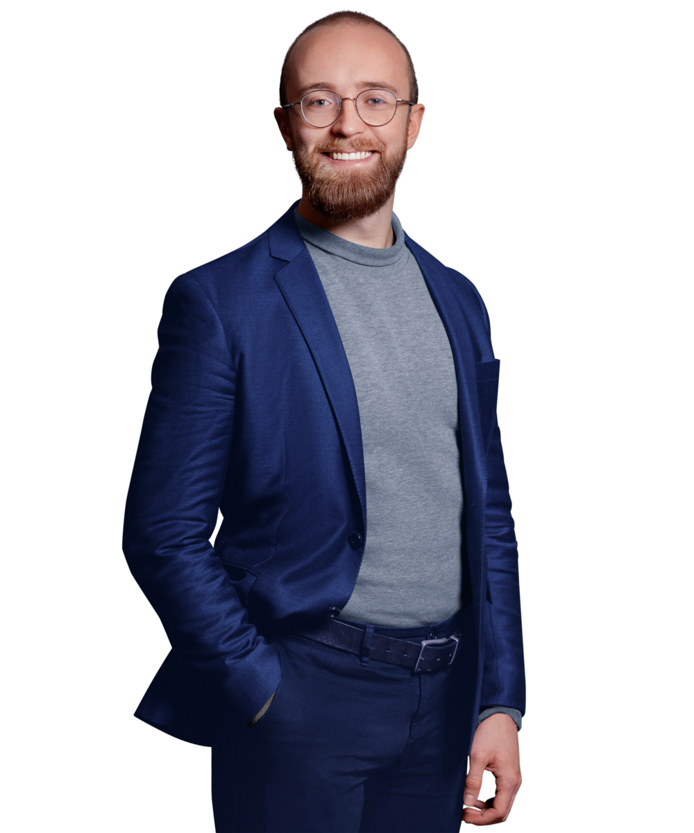 Portraitbild von Alexander Lackerschmid, Senior Software Engineer bei Kemény Boehme Consultants, der mit neutralem Gesichtsausdruck und der rechten Hand in der Hosentasche in die Kamera blickt
