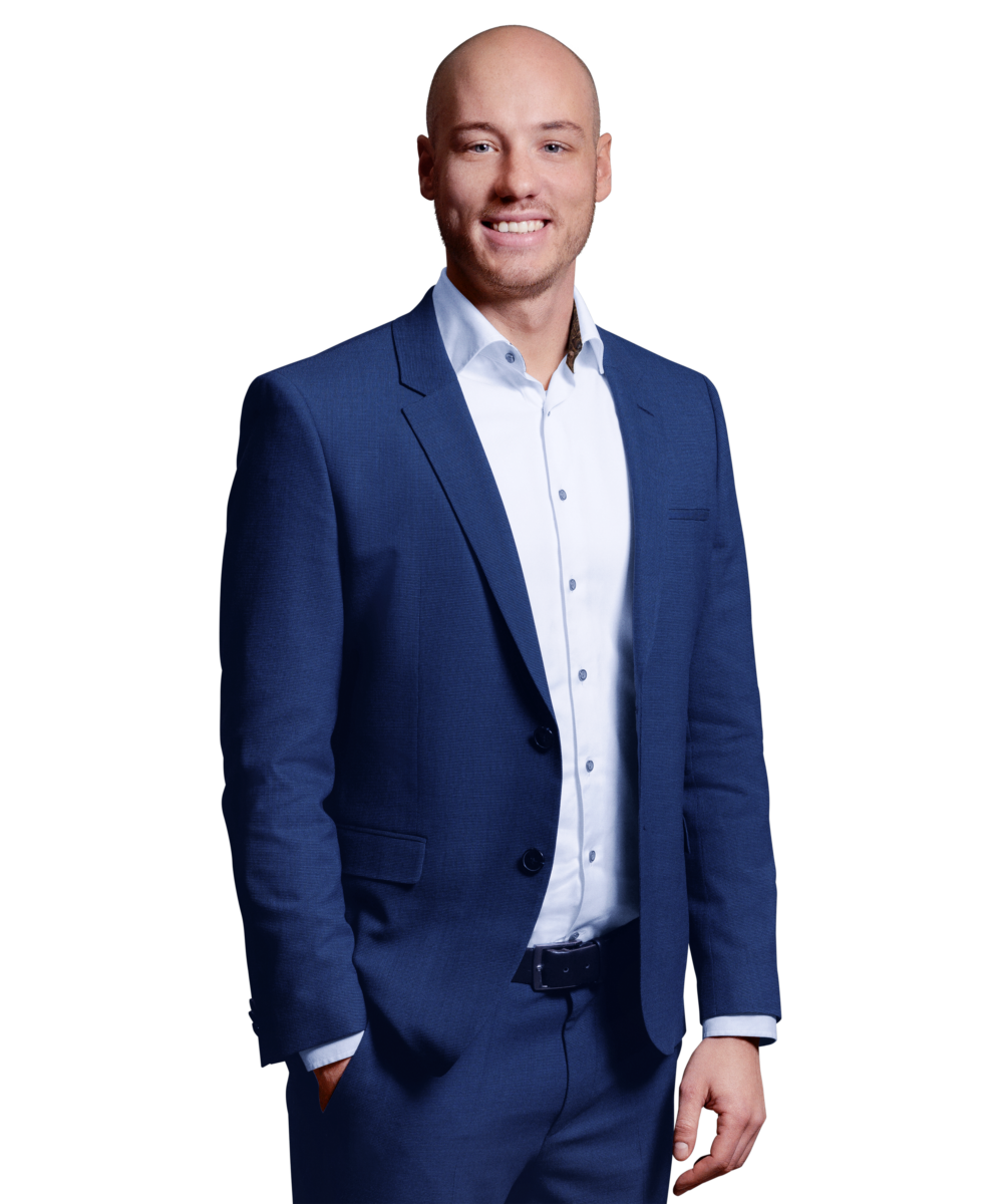 Portraitbild von Florian Scherzinger, Senior Consultant bei Kemény Boehme Consultants, der mit neutralem Gesichtsausdruck und der rechten Hand in der Hosentasche in die Kamera blickt