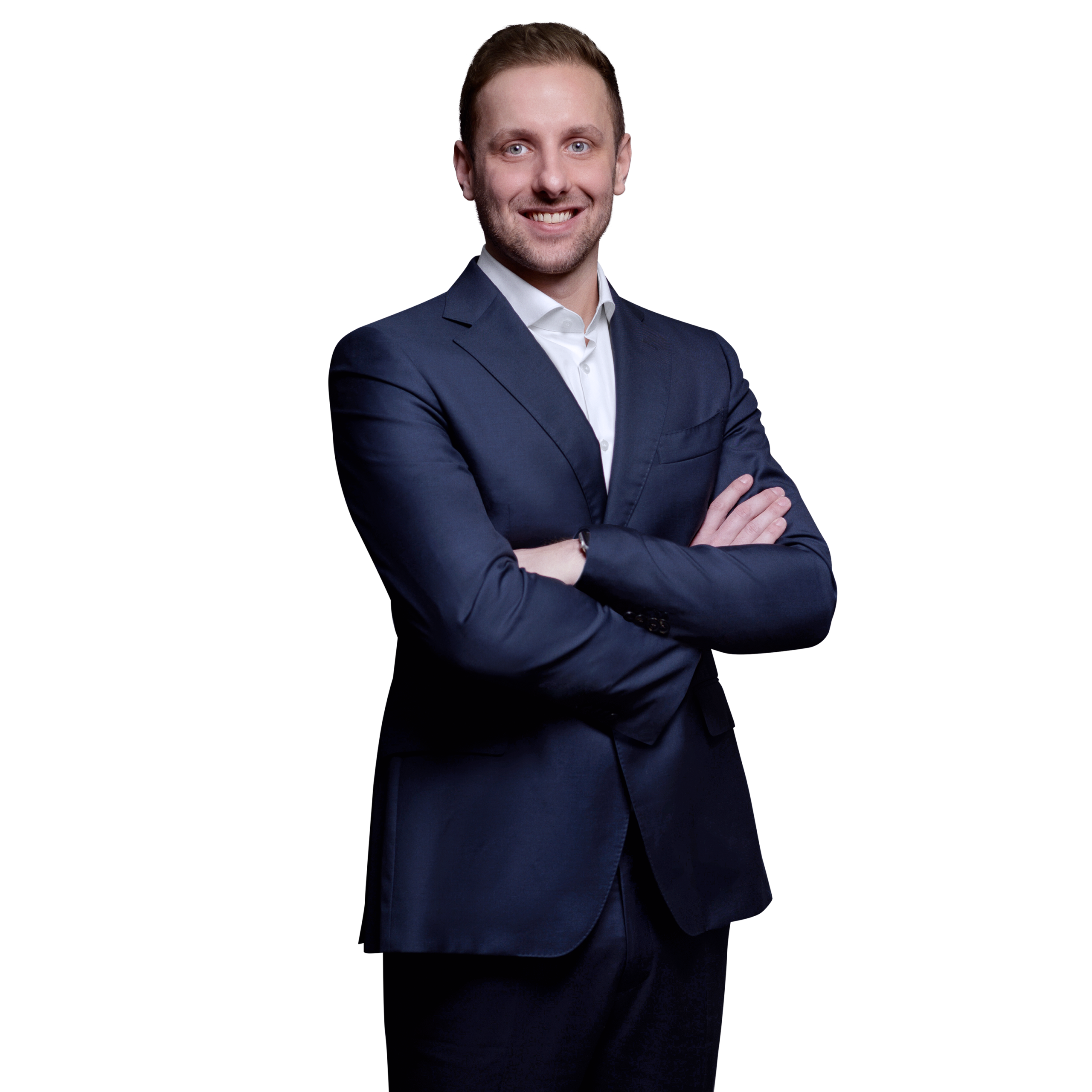 Porträtfoto von Marius Toews, Senior Consultant bei Kemény Boehme Consultants (KBC). Mann mit hellbraunen, nach hinten gestylten Haaren und blauen Augen, blickt breit lächelnd in die Kamera. Trägt ein dunkelblaues Sakko über einem weißen Hemd ohne Krawatte, Arme verschränkt mit sichtbarer Uhr am Handgelenk, selbstbewusste und offene Haltung.