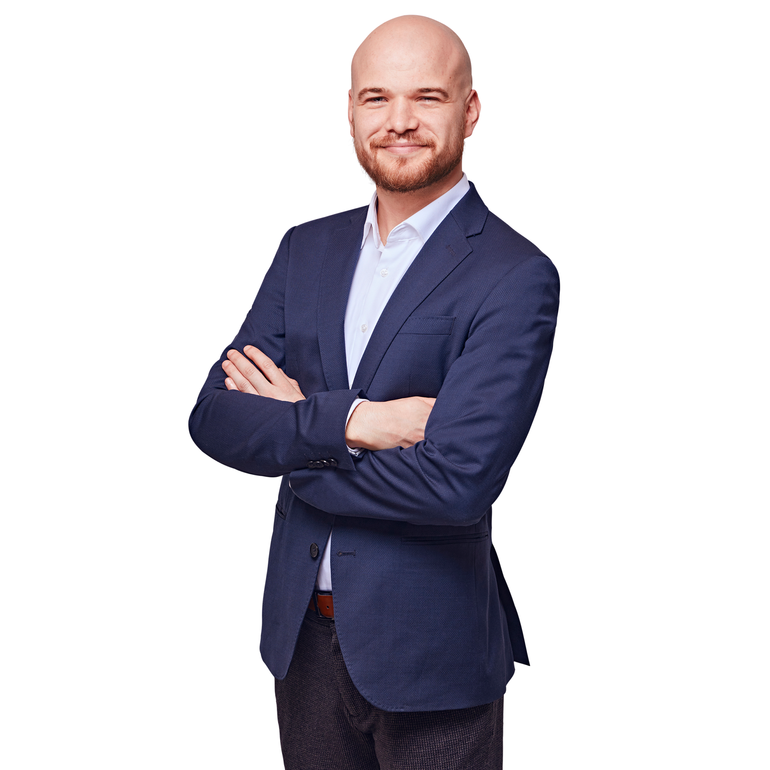 Porträtfoto von Fritz Anzinger, Senior Consultant bei Kemény Boehme Consultants (KBC). Mann mit rasiertem Kopf und gepflegtem rotblondem Vollbart blickt freundlich lächelnd in die Kamera. Trägt einen dunkelblauen Zweiknopf-Blazer über einem hellblauen Hemd ohne Krawatte sowie einen cognacfarbenen Gürtel, Arme selbstbewusst vor der Brust verschränkt, leicht zur Seite gedrehte, offene und charismatische Haltung.