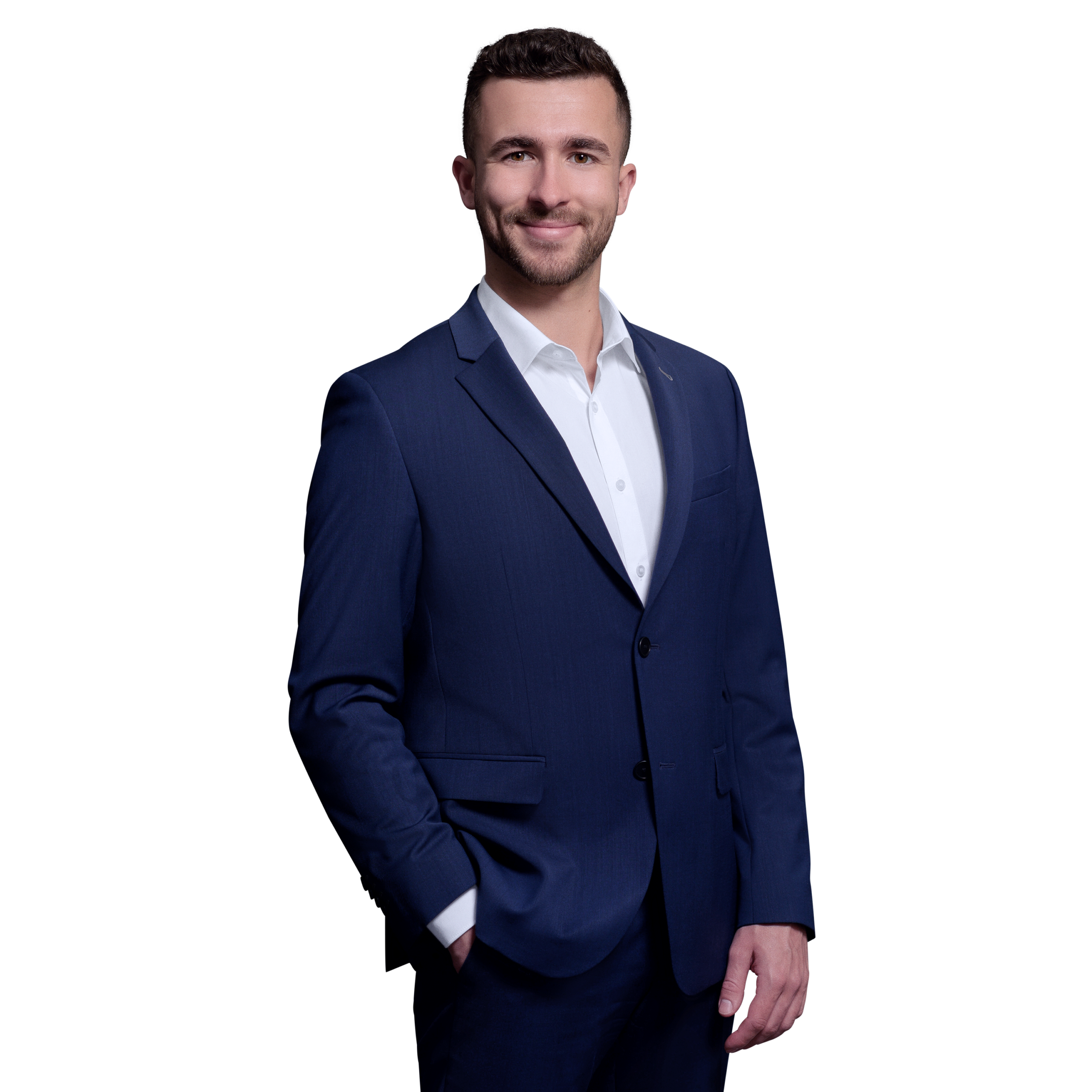 Porträtfoto von Tobias Wütherich, Senior Consultant bei Kemény Boehme Consultants (KBC). Mann mit kurzen dunkelbraunen Haaren und leichtem Bartschatten, blickt freundlich lächelnd in die Kamera. Trägt ein royalblaues Sakko über einem weißen Hemd ohne Krawatte, entspannte Haltung mit einer Hand in der Hosentasche.
