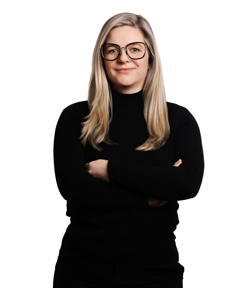Porträtfoto von Nadine von Splényi, Head of Marketing & PR bei Kemény Boehme Consultants (KBC). Frau mit langen blonden Haaren und eckiger schwarzer Brille, blickt selbstbewusst und freundlich in die Kamera. Trägt einen schwarzen Rollkragenpullover, Arme verschränkt vor der Brust.