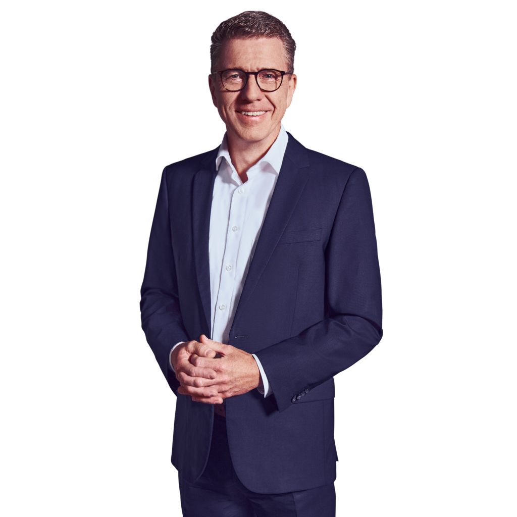 Portraitbild von Stefan Kemény, Senior Partner bei Kemény Boehme Consultants, der lächelnd mit verschränkten Händen vor dem Oberkörper in die Kamera blickt.