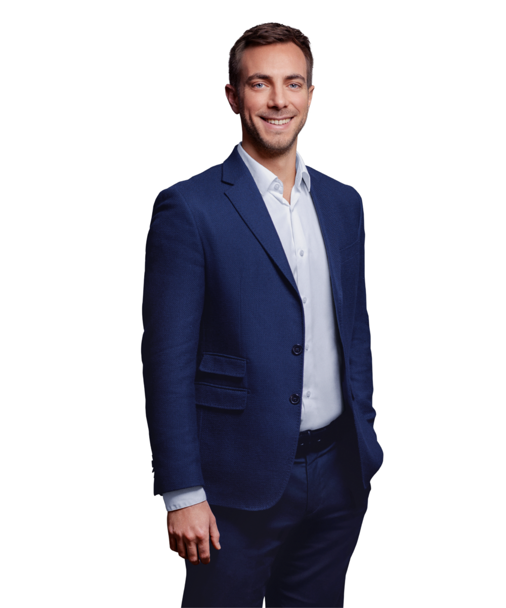Portrait photo of Johannes Stiegeler, a manager at Kemény Boehme Consultants (KBC). A man with short dark brown hair and blue eyes, smiling warmly at the camera. He is wearing a navy blue jacket over a light blue shirt.