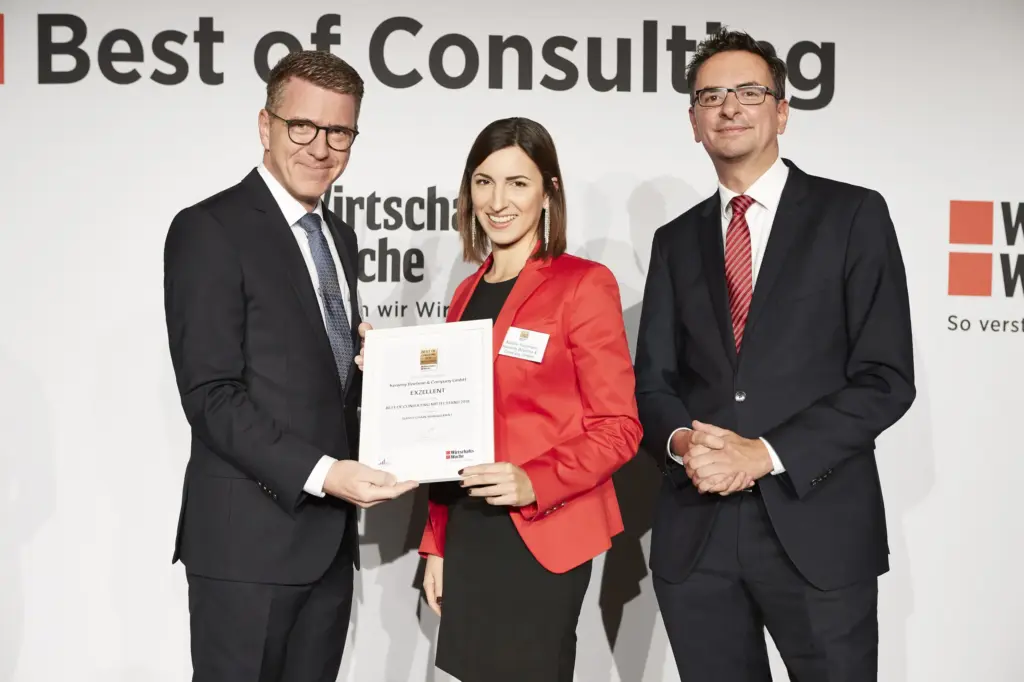 Verleihung des Best of Consulting Awards 2018 mit Stefan Kemény auf der linken Seite sowie einer Frau im roten Blazer und einem Herren im schwarzen Anzug. daneben.